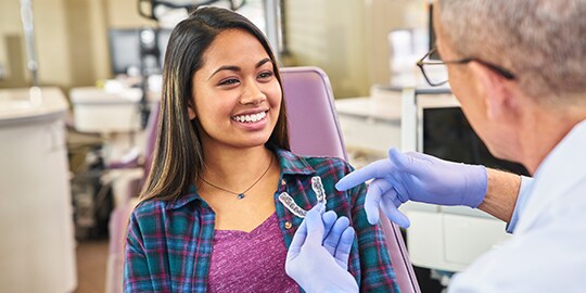 Orthodontist placing 3M Clarity Aligner for patient
